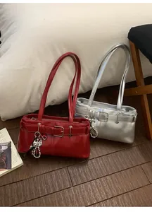 Detail of red and silver leather underarm bags with pearl charms and metal bows