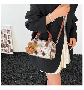 Close-up of contrast plush Boston bag with leather handles and bear charm detail