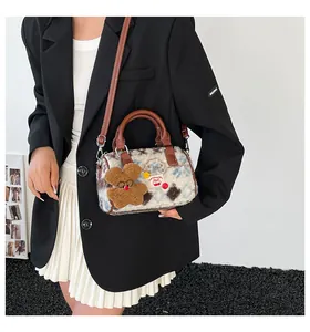 Detail of blue and brown checkered plush Boston bag with cute teddy bear charm