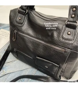 Detail view of black vintage faux leather bag with metal zippers and soft texture