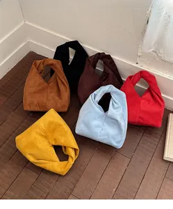 Macro shot of stylish pleated handbags in six vibrant colors on a wooden floor