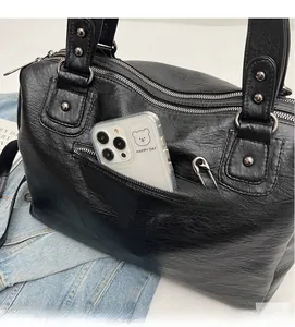 Detail view of large retro handbag zipper pocket showing ample phone storage space