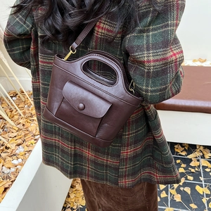 Retro dark brown bucket bag in matte PU leather shown against a stylish autumn background