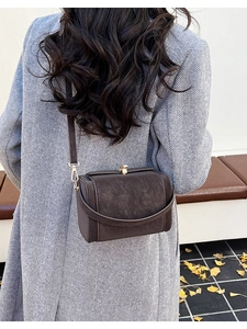 Close-up of a vintage brown square shoulder bag with gold metal buckle for autumn fashion