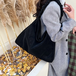 Minimalistische schwarze Schultertasche mit Falten für Damen in herbstlicher Kulisse