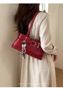 Red glossy leather underarm bag with decorative metal buckle and pearl ribbon charms