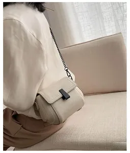 Detail of cream PU leather crossbody bag with black chain strap and metal clasp