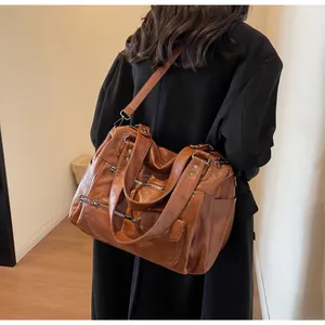 Back view of model wearing a vintage brown faux leather crossbody bag with metal zippers