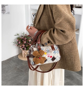 Detail of plush boston bag featuring faux shearling texture and teddy bear charm