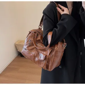 Detail view of retro brown faux leather tote bag with multi-pocket design on model