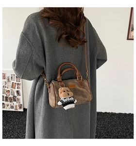 Braune Vintage-Boston-Tasche mit Bärenanhänger in einer stylischen Außenszene