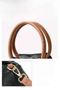 Detail of contrast stitching, brown leather handles, and gold metal hardware on cloud bag
