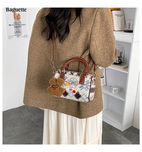 Detail of plush cow print Boston bag with brown leather strap and cute bear charm