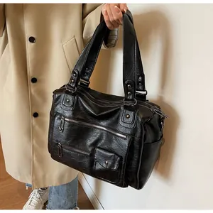 Close-up of retro black faux leather boston bag with multiple functional zip pockets