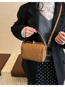 Close-up of vintage brown box bag with gold swivel lock and adjustable shoulder strap