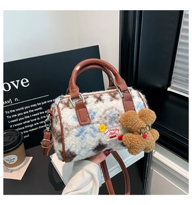 Detail of plush Boston bag featuring lamb wool texture with a cute bear charm and logo tag