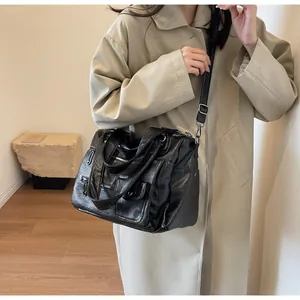 Model wearing a black multi-pocket crossbody bag with vintage textured leather finish