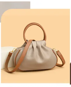 Close-up of pebble-grain leather texture and golden metal accents on the cloud bag