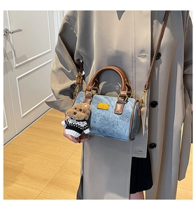 Detailansicht der blauen Boston-Tasche mit Ledergriffen und Bären-Plüschanhänger