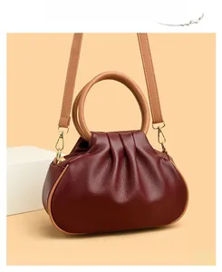Detail of burgundy ruched cloud bag showing premium lychee grain leather texture