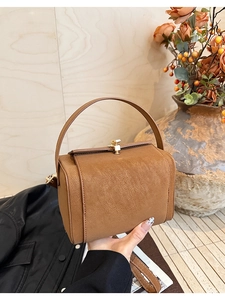 Macro detail of vintage brown cracked leather texture and metallic buckle closure on the bag