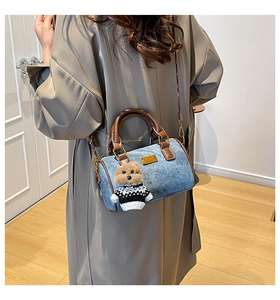 Detail der hellblauen Denim Boston Bag mit braunen Lederriemen und süßem Bären-Anhänger