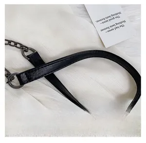 Detail of a black PU leather shoulder strap with a dark grey metal chain and fine stitching