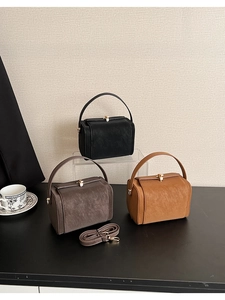 Three elegant vintage-style handbags in black, dark brown, and caramel with metal clasps