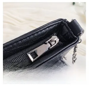 Close-up of premium silver metal zipper slider on a black lychee texture PU leather bag
