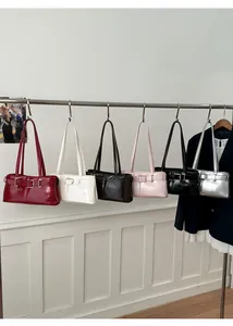 Row of minimalist leather underarm bags in six colors with decorative buckle straps