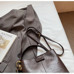 Detailed close-up of brown vintage bucket bag featuring textured leather and brand tag
