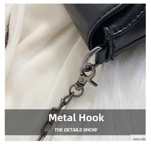 Detail of high-quality metal swivel hook and chain on black leather fringe crossbody bag
