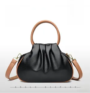 Detail of lychee pattern leather texture and gold hardware on black cloud tote bag