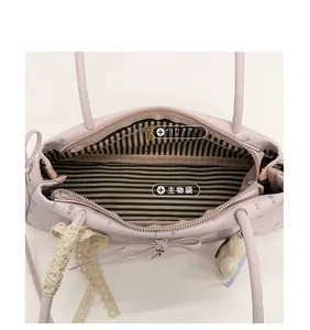 Détail intérieur du sac floral montrant la doublure rayée et la poche zippée