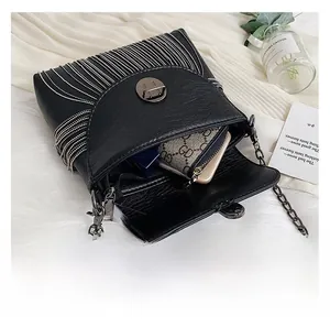 Detail view of black tassel bag interior showing capacity for wallet and lipstick