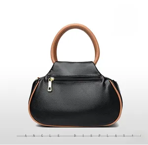 Back view of black pebble leather tote bag with brown handles and golden zip pocket
