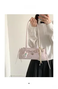 Détail du sac baguette à fleurs roses avec nœud, pendentif cœur et breloque lapin