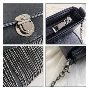 Detail of silver chain tassels and polished metal hardware on black PU leather handbag