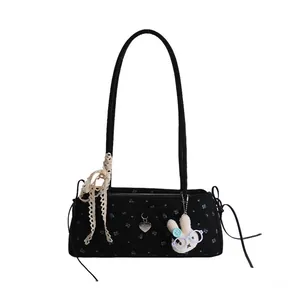 Détail du sac noir à fleurs avec nœud en dentelle, pendentif cœur et breloque lapin