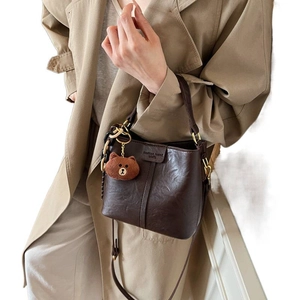Retro dark brown bucket bag with lychee texture, top handle, and cute bear pendant