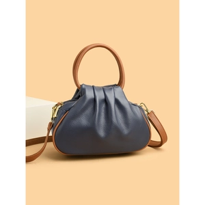 Navy blue ruched dumpling bag with brown round handles and crossbody strap