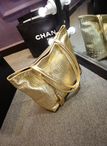 Vue détaillée du sac cabas doré avec texture crocodile et finition métallique brillante