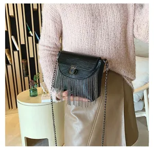 Detail of a vintage black PU crossbody bag featuring fringe metal chains and a lock buckle
