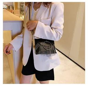 Detail of black fringe crossbody bag with silver metal ring and chain tassels decoration