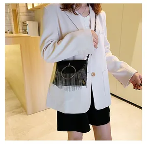 Detail shot of a black PU crossbody bag with silver fringe and metal ring on model