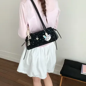 Détail du sac floral en velours avec breloque cœur et accessoire lapin en peluche