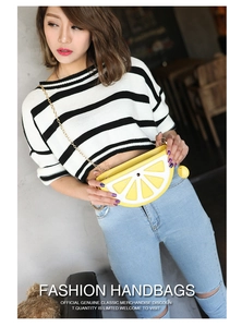 Detail showing the lemon shaped crossbody bag with yellow slices and metal chain strap