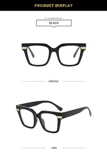 Detail view of large square black glasses frame with golden metal hinges and accents