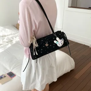Détail du sac floral en velours avec nœud en dentelle et breloque lapin mignon