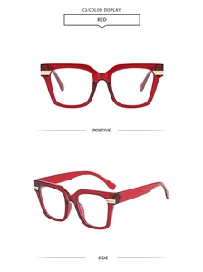 Detail view of transparent red square frame glasses with golden metal accents on temples